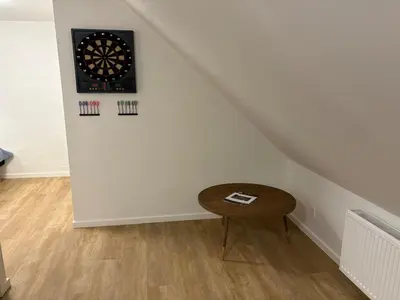 a room with a table and a dart board on the wall at Holiday Home Elida - 400m from the sea by Interhome in Hanstholm