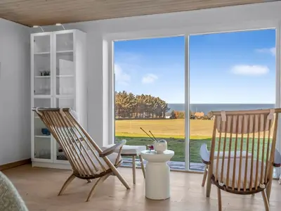 a room with two chairs and a table and a large window at Holiday Home Elida - 400m from the sea by Interhome in Hanstholm