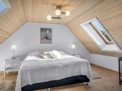 a bedroom with a white bed in a attic at Holiday Home Elida - 400m from the sea by Interhome in Hanstholm