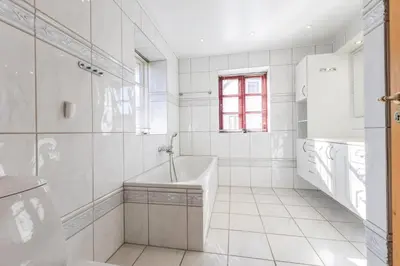 a white bathroom with a tub and a sink at 3007Møllehuset - Stuehus in Blokhus