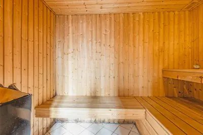 a sauna with wooden walls and a wooden floor at 3007Møllehuset - Stuehus in Blokhus
