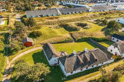 an aerial view of an old farmhouse with a grass roof at 3007Møllehuset - Stuehus in Blokhus