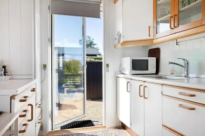 a kitchen with a door leading to a patio at LF14058-Roslev-Eskovvej-58 in Roslev