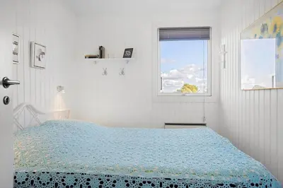 a white bedroom with a bed and a window at LF14058-Roslev-Eskovvej-58 in Roslev