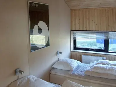 a bedroom with two beds and a mirror and a window at Holiday home in Thisted with swimming pool in Thisted