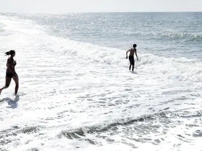 two people walking in the water on the beach at Holiday home in Thisted with swimming pool in Thisted
