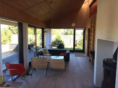 a living room with a couch and a table and chairs at Holiday home in Thisted with swimming pool in Thisted