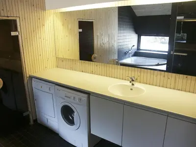 a bathroom with a sink and a washing machine at Holiday home in Thisted with swimming pool in Thisted