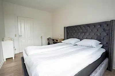 a large bed with a black headboard in a bedroom at Holstebro Apartments in Holstebro