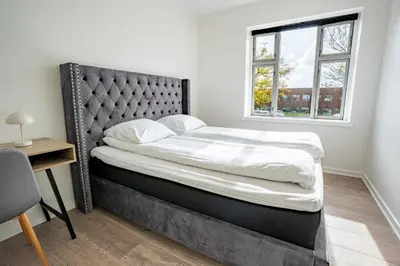 a large bed in a room with a window at Holstebro Apartments in Holstebro