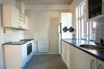 a kitchen with white cabinets and a sink at Holstebro Apartments in Holstebro