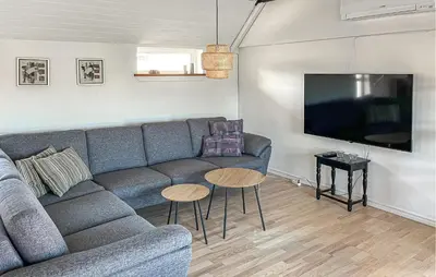a living room with a couch and a flat screen tv at 3 Bedroom Nice Home In Blokhus in Blokhus