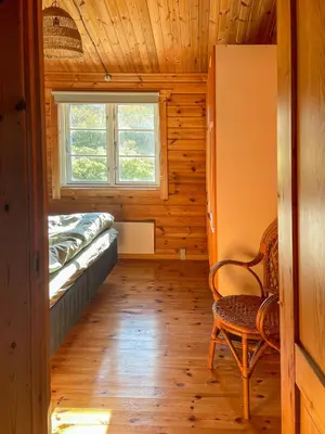 a small room with a chair and a window at Authentic Wooden House By The North Sea in Vestervig