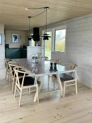 a dining room with a large table and chairs at Holiday Home With Pool And Fjord Views On Lundø in Højslev