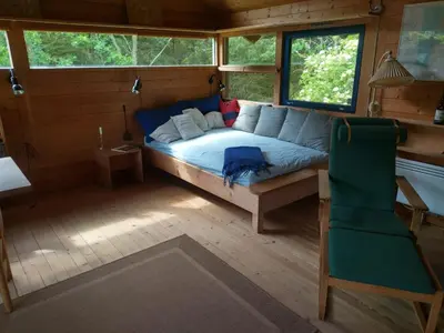 a bedroom with a bed and a chair in a room at Kathøje in Lemvig