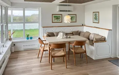 a dining room with a table and chairs and a couch at Cozy Home In Struer With Sauna in Struer