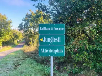 a green street sign on the side of a road at 4 star holiday home in Løgstør in Løgstør