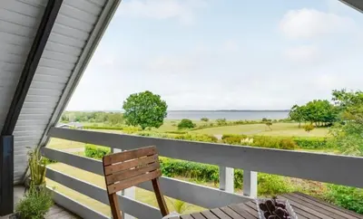a porch with a bench and a view of the ocean at Fjord Views And Spa By Limfjorden in Roslev