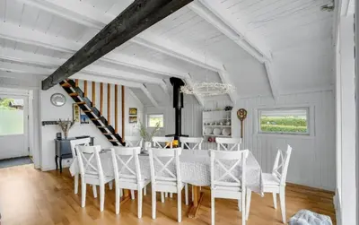 a dining room with a table and white chairs at Fjord Views And Spa By Limfjorden in Roslev