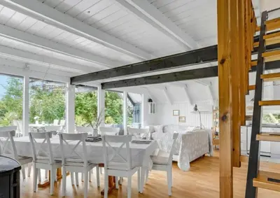 a dining room with a white table and chairs at Fjord Views And Spa By Limfjorden in Roslev