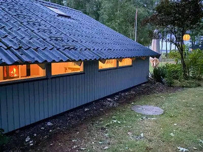 a house with a blue roof and windows at Holiday Home Between Beach And Forest On Mors in Øster Assels