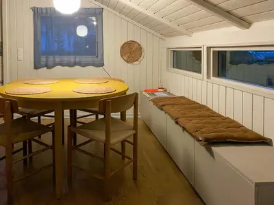 a room with a table and chairs and a bench at Holiday Home Between Beach And Forest On Mors in Øster Assels