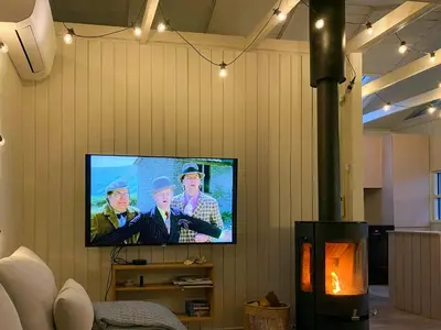 a television on a wall with three men on it at Holiday Home Between Beach And Forest On Mors in Øster Assels