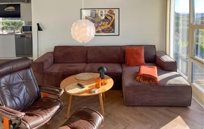 a living room with a brown couch and a table at 3 Bedroom Gorgeous Home In Hurup Thy in Doverodde
