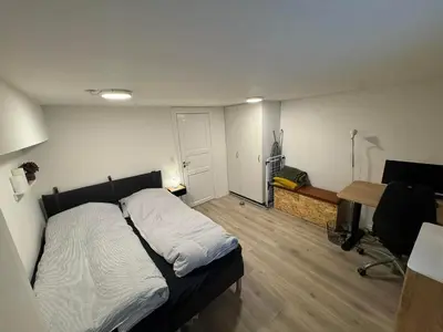 a bedroom with a bed and a desk with a computer at Østerbrogade 49 in Holstebro