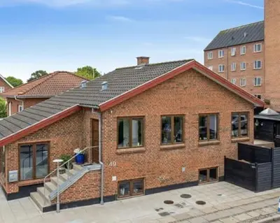 a red brick house with a roof at Østerbrogade 49 in Holstebro