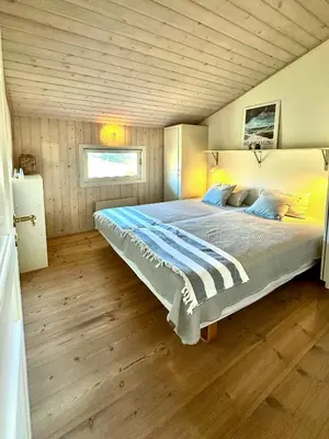 a bedroom with a large bed with a wooden ceiling at Bright Holiday Home Close To Sea Near Blokhus in Blokhus