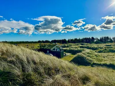 a house in the middle of a grassy field at Bright Holiday Home Close To Sea Near Blokhus in Blokhus