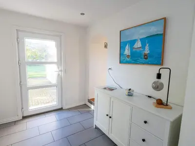 a room with a white dresser with a painting of boats on the wall at 4 star holiday home in Hanstholm in Hanstholm