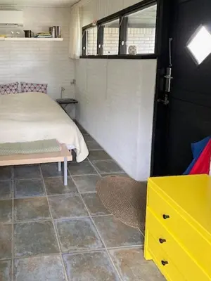 a bedroom with a bed and a yellow dresser at Summerhouse By The Heath Near The North Sea in Snedsted