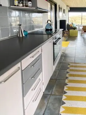 a kitchen with a black counter top in a room at Summerhouse By The Heath Near The North Sea in Snedsted
