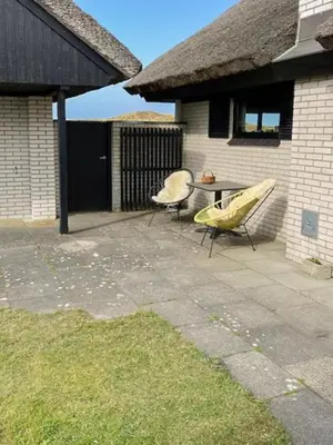a backyard with a slide and a table and a house at Summerhouse By The Heath Near The North Sea in Snedsted
