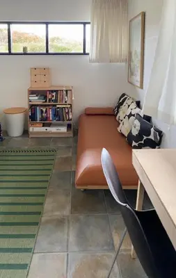 a living room with a couch and a book shelf at Summerhouse By The Heath Near The North Sea in Snedsted