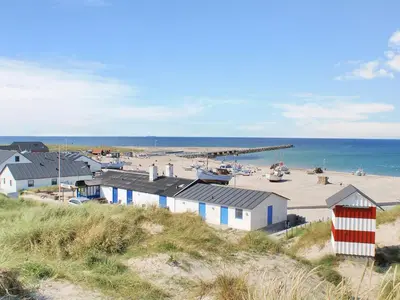 a beach with a bunch of buildings and the ocean at Holiday Home Gisa - 500m from the sea by Interhome in Thisted