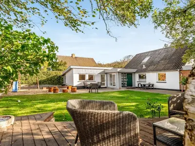 a patio with chairs and a yard withgrass at Holiday Home Missa - 2km to the fjord by Interhome in Ejerslev