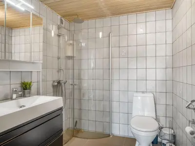 a bathroom with a toilet and a sink and a shower at Holiday Home Missa - 2km to the fjord by Interhome in Ejerslev