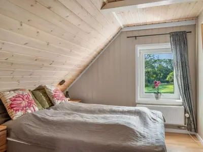 a bedroom with a bed and a window at Holiday Home Missa - 2km to the fjord by Interhome in Ejerslev