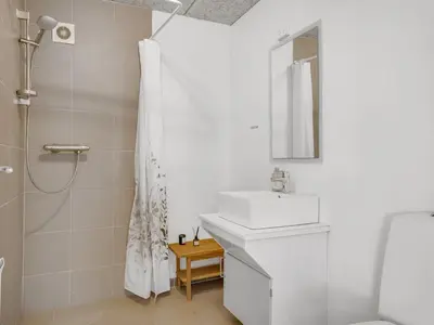 a white bathroom with a sink and a shower at Holiday Home Nette - 2km to the fjord by Interhome in Thyholm