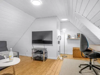 a living room with a couch a table and a tv at Holiday Home Amber - 300m from the sea by Interhome in Harboør