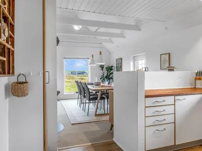 a kitchen and dining room with a table and chairs at Holiday Home Amber - 300m from the sea by Interhome in Harboør