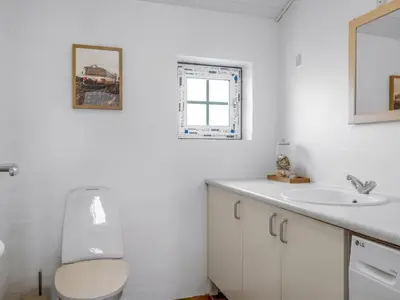 a white bathroom with a toilet and a sink at Holiday Home Amber - 300m from the sea by Interhome in Harboør