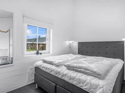 a bedroom with a large bed and a window at Holiday Home Amber - 300m from the sea by Interhome in Harboør