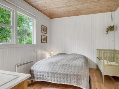a white bedroom with a bed and two windows at Holiday Home Ingamaj - 4km from the sea by Interhome in Brovst