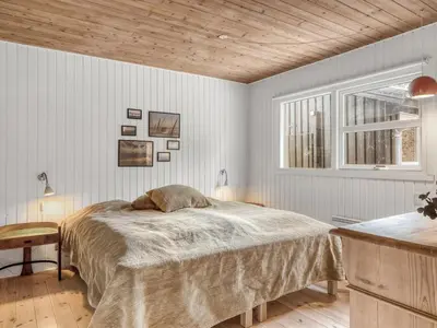 a bedroom with a bed and a wooden ceiling at Holiday Home Ingamaj - 4km from the sea by Interhome in Brovst