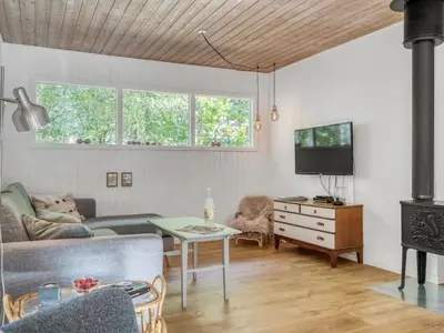 a living room with a couch and a tv and a table at Holiday Home Ingamaj - 4km from the sea by Interhome in Brovst