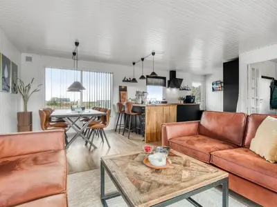 a living room with a couch and a table at Holiday Home Sarika - 500m from the sea by Interhome in Fjerritslev